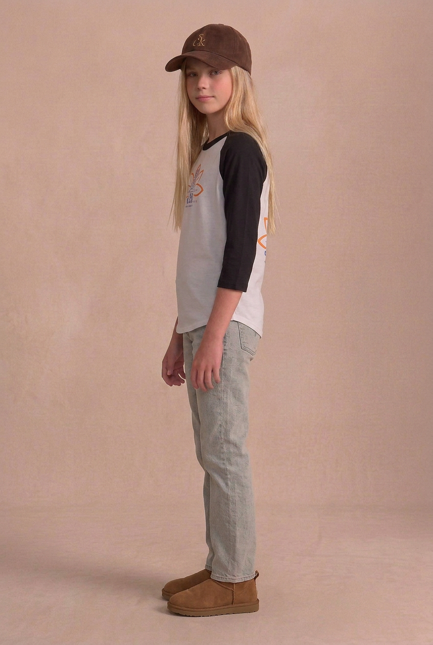 Model turned farther to the side in the yoga raglan, faded jeans and chestnut boots