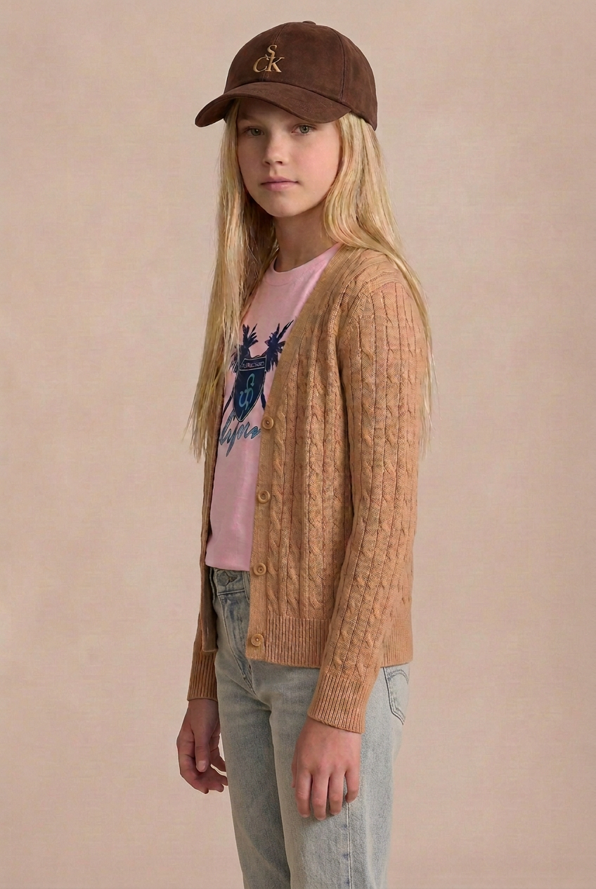Model with weathered faded denim barely showing beneath her cardigan